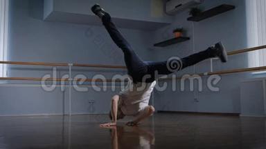 专业的舞蹈演员在舞蹈工作室的地板上表演复杂的舞蹈练习。 小男孩在旋转